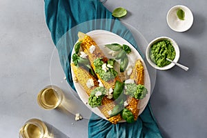 Sweet fried corn with basil sauce, feta cheese, wine top view