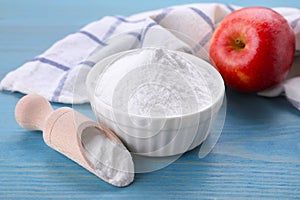 Sweet fructose powder and apple on light blue wooden table