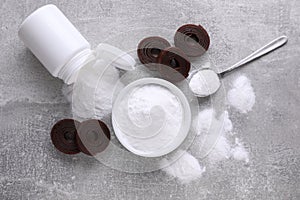 Sweet fructose powder and fruit leather rolls on light grey table, flat lay