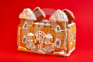 Sweet gingerbread house with icing decor on red background