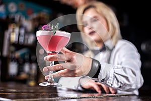 Sweet girl bartending demonstrates the process of making a cocktail at bar