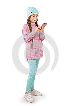 A sweet girl holds a smart phone in her hands and smiles. Isolated on a white background.