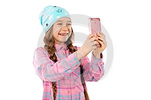 A sweet girl holds a smart phone in her hands and smiles. Isolated on a white background.