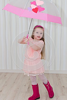 Sweet girl with a pink umbrella at home