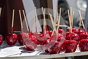 Sweet glazed red toffee candy apples on sticks photo