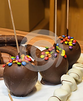 Sweet glazed red toffee candy apples on sticks for sale on farmer market or country fair