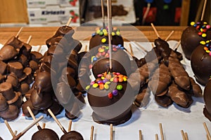Sweet glazed red toffee candy apples on sticks for sale on farmer market or country fair