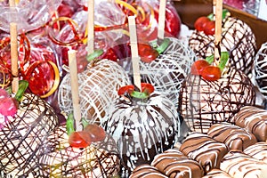 Sweet glazed red toffee candy apples on sticks for sale on farmer market or country fair