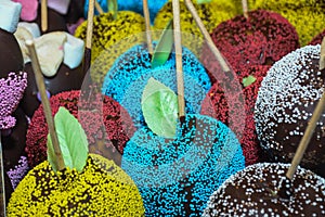 Sweet glazed red toffee candy apples on sticks for sale on farmer market or country fair