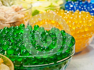 Sweet green jelly bubble in glass bowl. Green tapioca ball or boba.