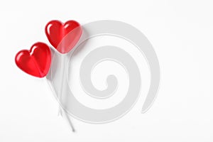 Sweet heart shaped lollipops on white background, flat lay with space for text. Valentine`s day celebration