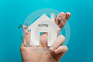 Sweet home. Hand holding white paper house figure on blue background. Real Estate Concept. Ecological building. Copy