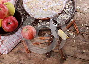 Sweet homemade apple cake with cinnamon and fresh apples on a rustic wooden table