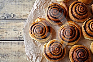 Sweet Homemade christmas baking. Cinnamon rolls buns with cocoa filling on parchment paper. Kanelbulle swedish dessert.