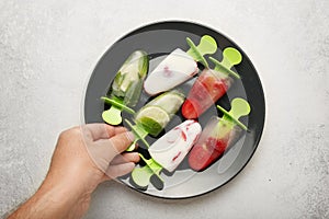 Sweet homemade dessert, popsicles sorbet for summer coolness. Frozen juice and ice cream. Children hands