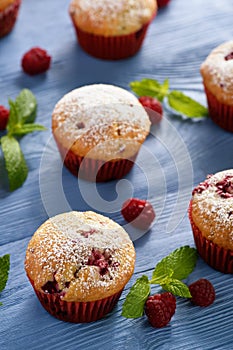 Sweet homemade raspberry muffins on wooden table.