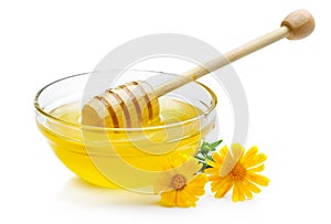 Sweet honey in glass bowl isolated with wooden dipper