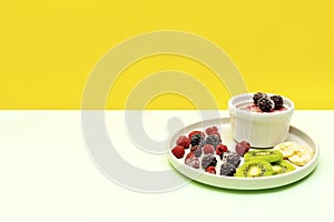 Sweet ice cream yogurt with frozen banana kiwi fruits, blackberry, raspberry berries. Cold fresh summer homemade dessert food on