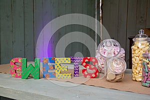 sweet jars filled with retro sweets next to a sign reading sweets