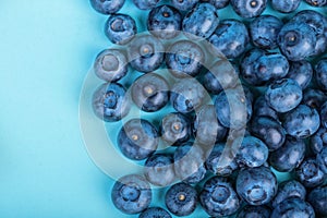 Sweet and juicy bilberries. Blueberries on a bright blue background, top view. Healthful and tasty berries, close-up. Summer fruit