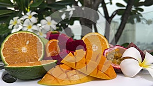 Sweet juicy ripe yellow mangoes on a green background under harsh shadow