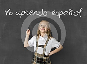 Sweet junior blond schoolgirl smiling happy in children learning spanish language and education concept photo