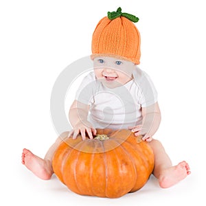 Sweet laughing baby girl with huge pumpkin