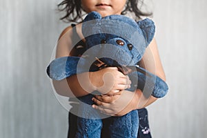 Sweet little asian girl hugging her favorite toy teddy bear