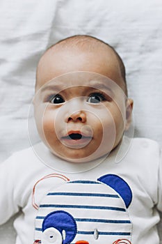 Sweet little baby boy with chubby cheeks and big eyes. Portrait of happy smiling infant