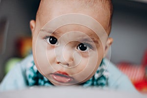 Sweet little baby boy with chubby cheeks and big eyes. Portrait of happy smiling infant