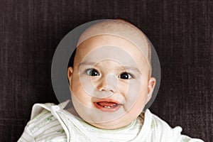 Sweet little baby boy with chubby cheeks and big eyes. Portrait of happy smiling infant