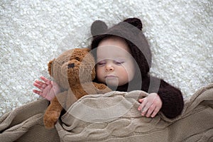 Sweet little baby boy, dressed in handmade knitted brown soft te