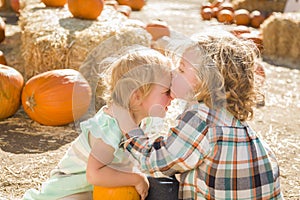 Sweet Little Boy Kisses His Baby Sister at Pumpkin