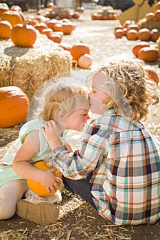 Sweet Little Boy Kisses His Baby Sister at Pumpkin Patch