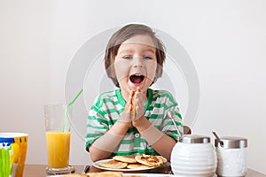 Sweet little caucasian boy, eating pancakes