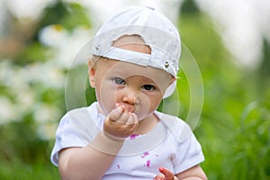 Sweet little child, baby boy, eating cherries in garden, enjoying tasty fruit