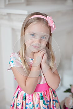 Sweet little girl holding her hands under her chin