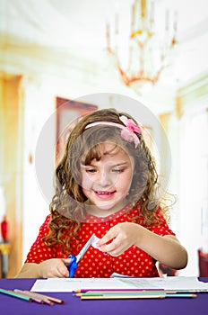 Sweet little girl using scissors