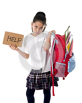 Sweet little mexican school girl carrying heavy backpack or schoolbag full