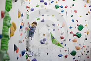 Sweet little preschool boy, climbing wall indoors