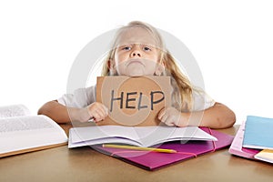 Sweet little school girl holding help sign in stress with books and homework