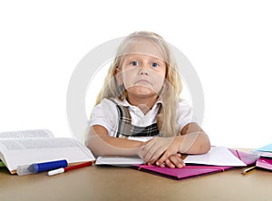 Sweet little school girl tired and sad in stress with books and homework