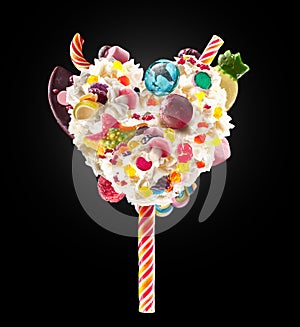 Sweet Lolipop in Heart form of whipped cream with sweets, jellies, heart front view. Crazy freakshake food trend. Front