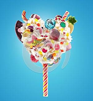 Sweet Lolipop in Heart form of whipped cream with sweets, jellies, heart front view. Crazy freakshake food trend. Front