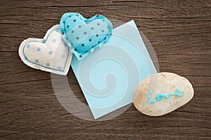 Sweet love hearts and blue blank paper on wood