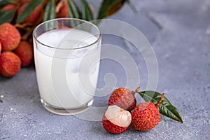 Sweet lychee juice on the gray background Closeup of fresh lychee juice with fruits