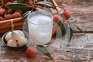 Sweet lychee juice on the wooden rustic background Closeup of fresh lychee juice with fruits