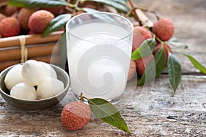 Sweet lychee juice on the wooden rustic background Closeup of fresh lychee juice with fruits