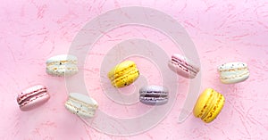 Sweet macaroons macarons on pink background. French cookies vanilla, raspberry, lemon strawberry