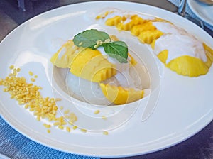 sweet mango with sticky rice with coconut milk on white plate